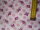 Weißer Baumwollstoff mit rosa und pinken Schmetterlingen und Blümchen